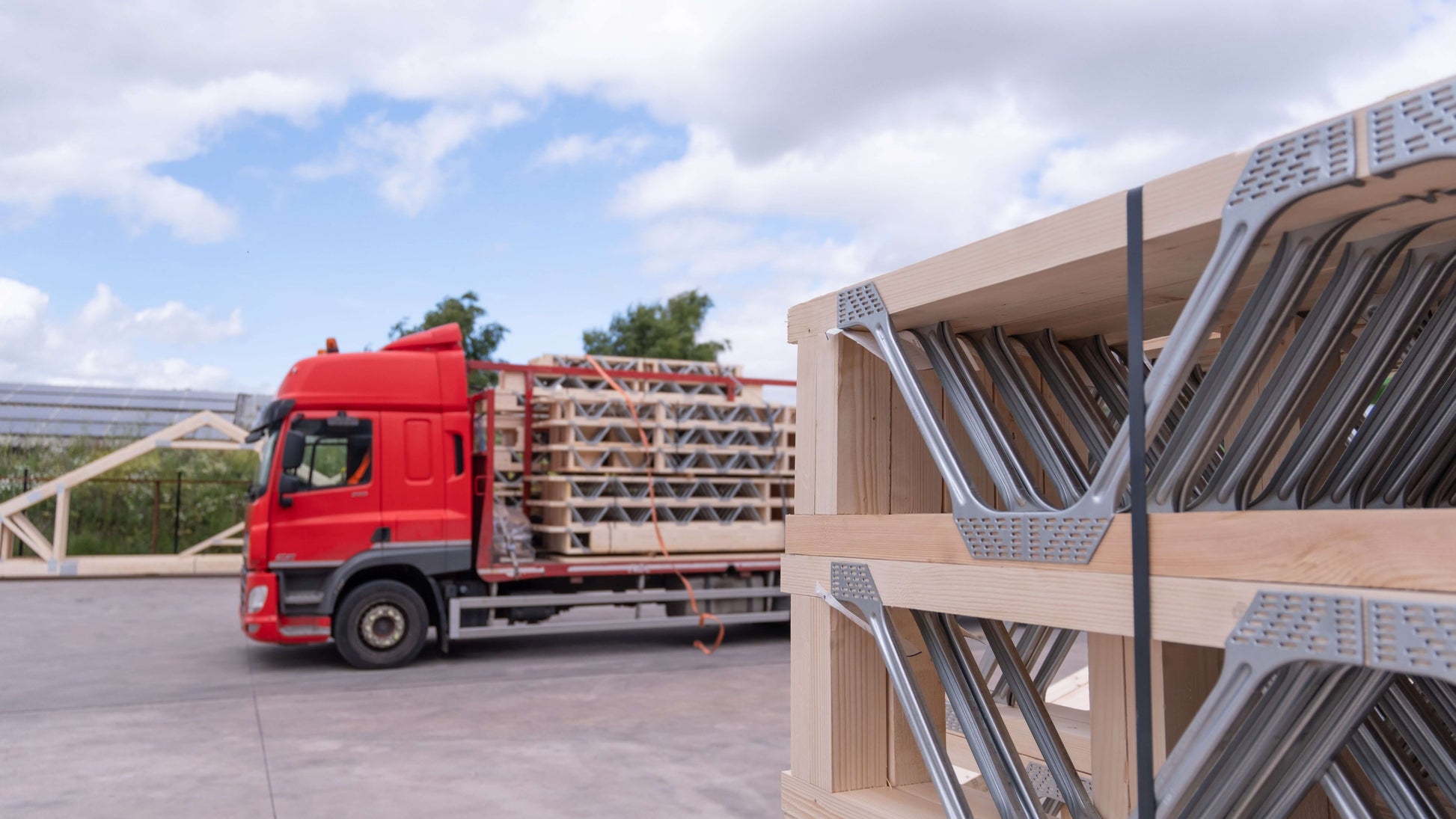 posi-joists stacked up in front of a loaded lorry