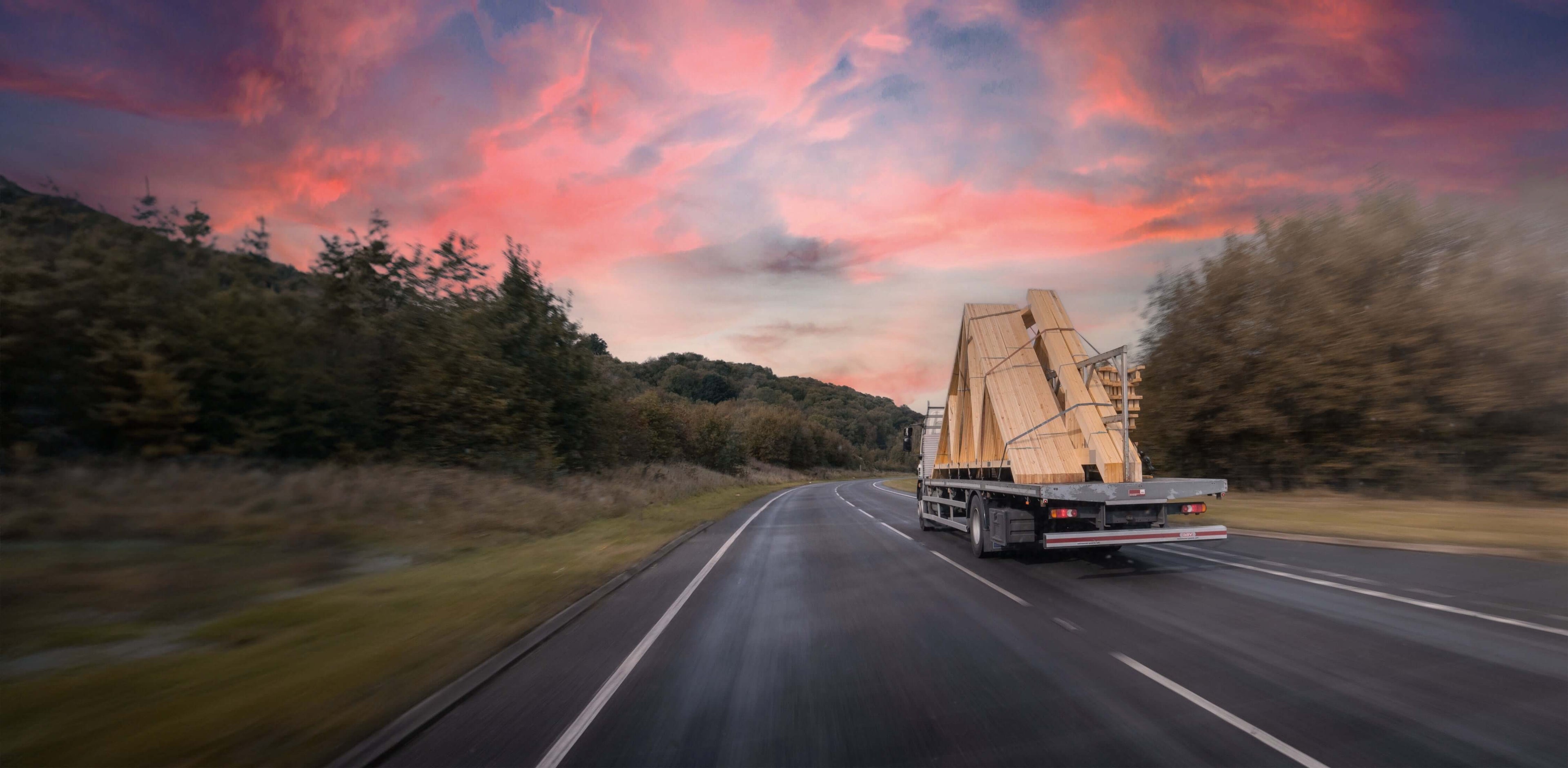 trusses on lorry with sunset behind